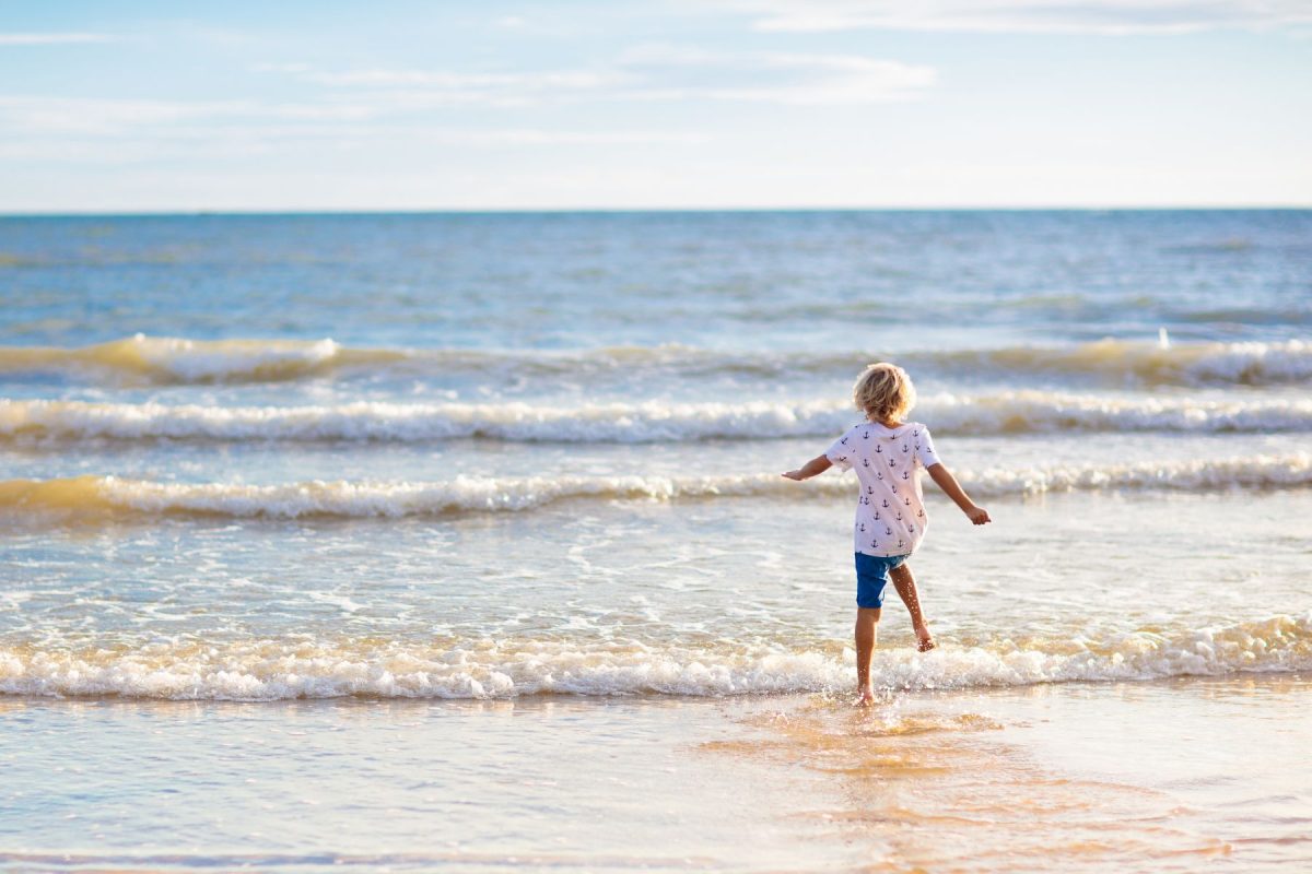 Child running into water on Keewaydin Island.