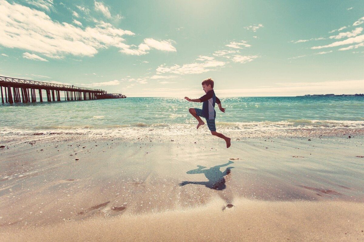 boy skipping on the beach