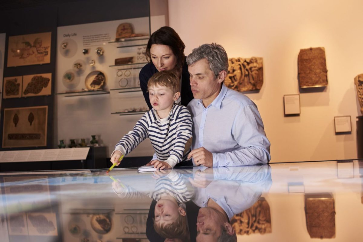 family observing an exhibit at the museum. 