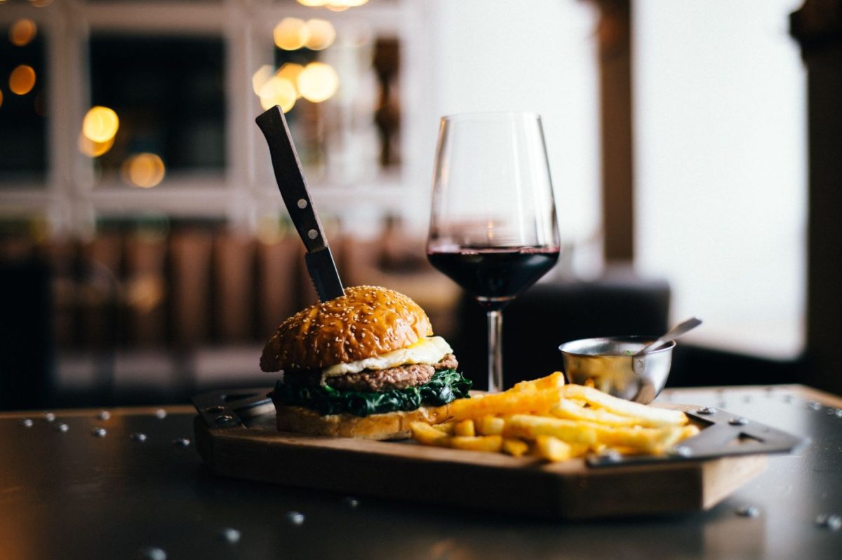 burger with side of fries and glass of red wine